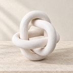 Knot white three-link wooden accent resting on a pale stone surface