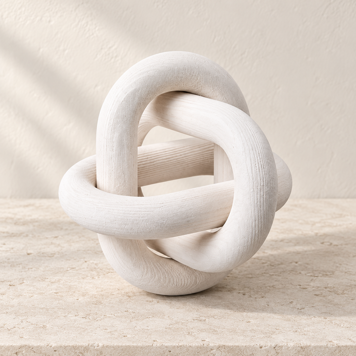 Knot white three-link wooden accent resting on a pale stone surface