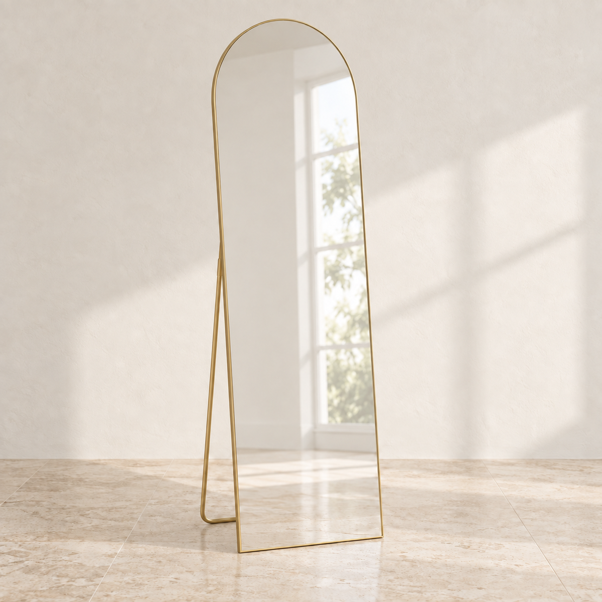 Linea arched full-length mirror with a gold-tone frame in a sunlit room