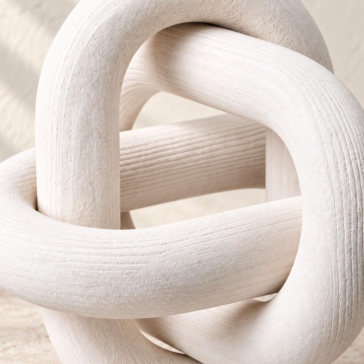 Angled close-up of the interlocking white wooden links on Knot