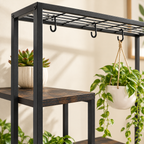 Close-up of the Aster plant stand black metal top rail, hanging hooks, and engineered wood shelf