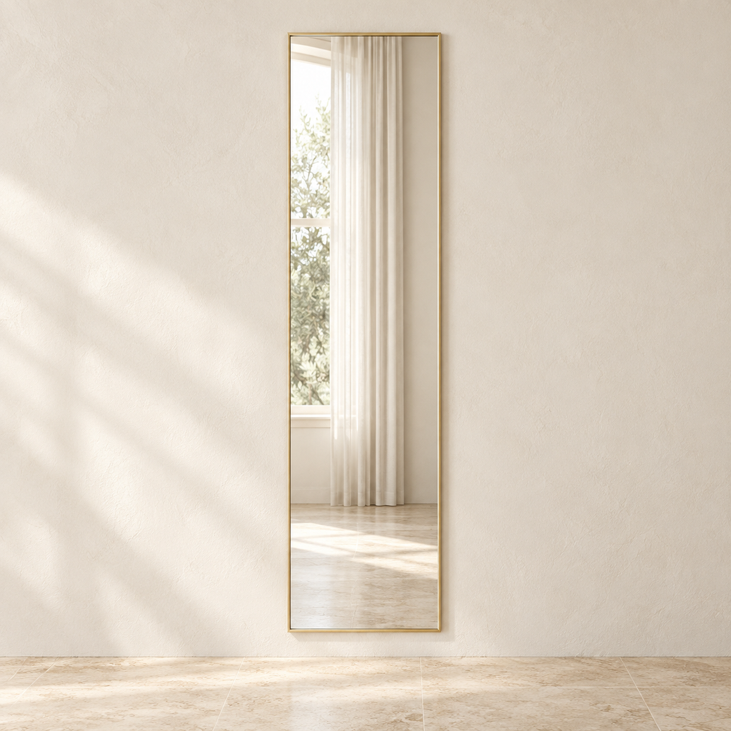 Linea rectangular full-length mirror with a gold-tone frame reflecting a window