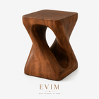 The Sculpt Accent Table in a walnut finish with a twisted hourglass silhouette and open center.