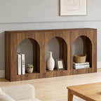 Warm wood arched console table styled with books, a plant, vase, picture frame, basket, and magazines in a minimalist living room.