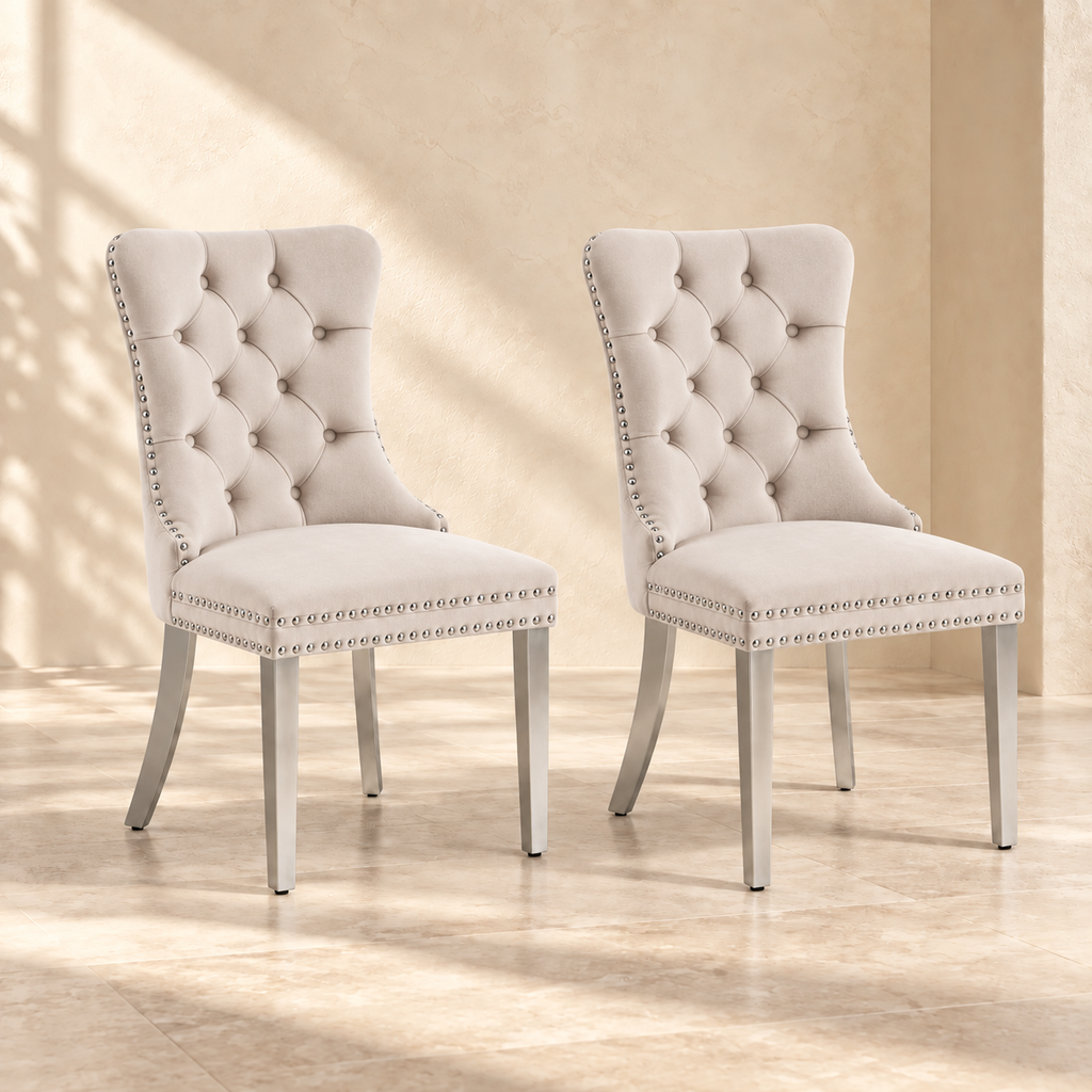 Two Elara beige velvet dining chairs with chrome legs in a warm cream interior
