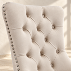 Close-up of Elara beige velvet button tufting and silver nailhead trim