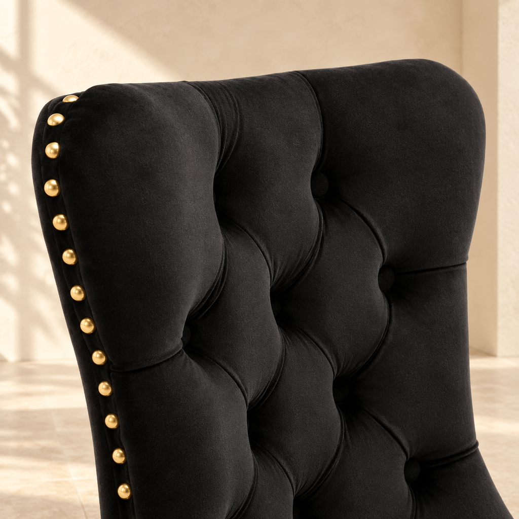 Close-up of Elara black velvet button tufting and gold nailhead trim