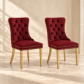 Two Elara burgundy velvet dining chairs with polished gold legs in a cream interior