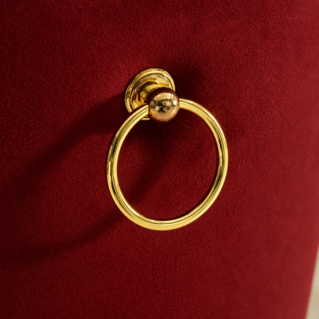 Polished gold ring pull on the burgundy velvet back of an Elara chair