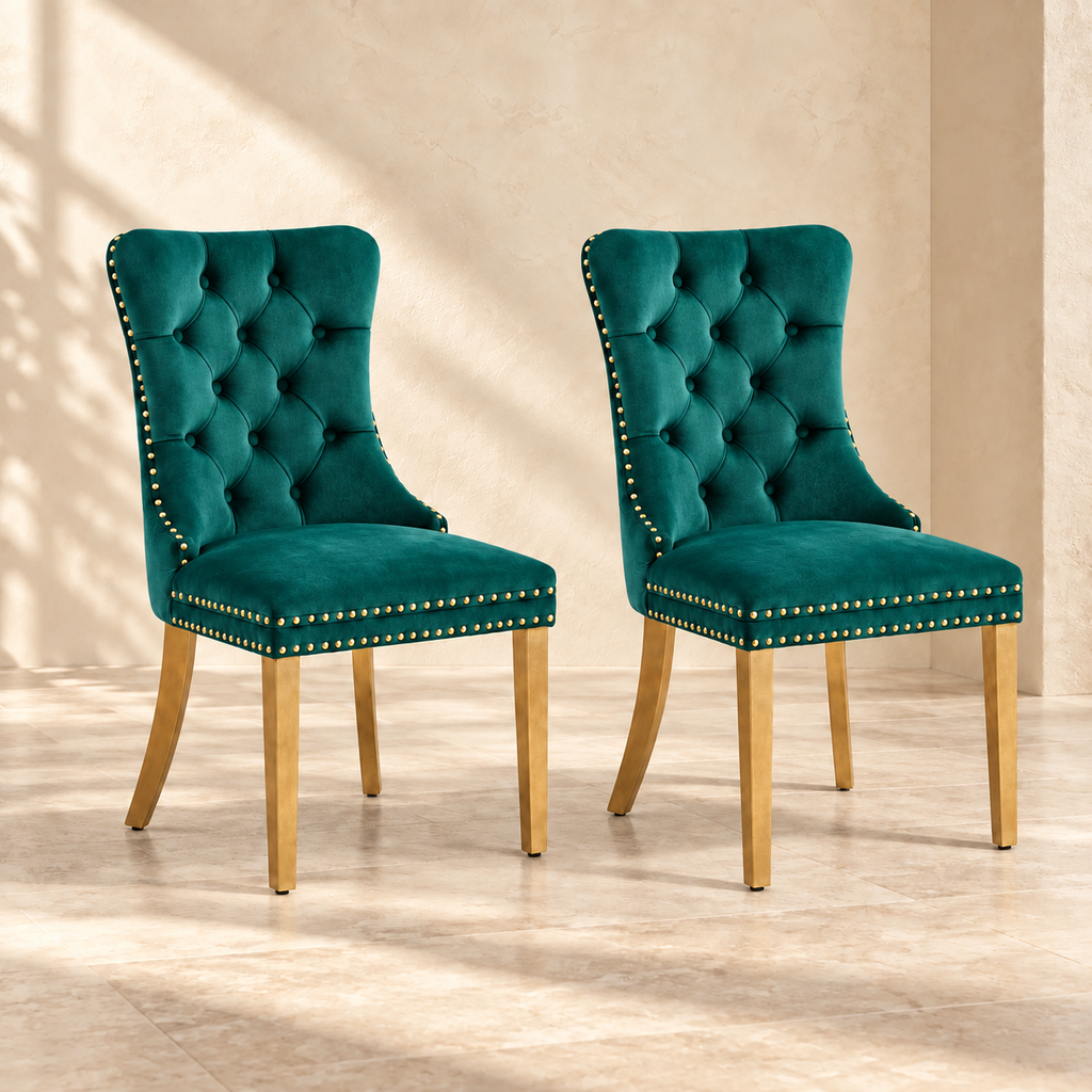 Two Elara green velvet dining chairs with gold-tone legs in a warm cream interior