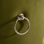 Polished chrome ring pull on the olive velvet back of an Elara dining chair