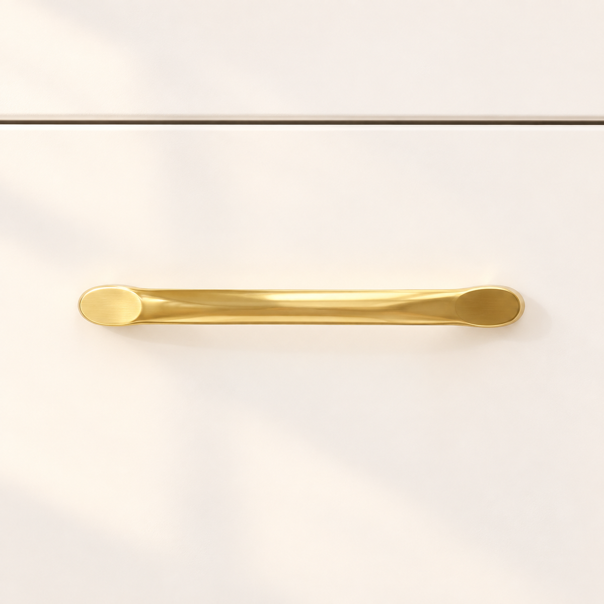 Close-up of the Iris vanity’s curved gold-tone handle and smooth white drawer front