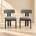 Two Nola black-and-white upholstered dining chairs in a warm cream interior