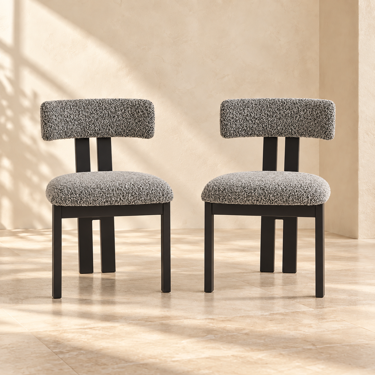 Two Nola black-and-white upholstered dining chairs in a warm cream interior