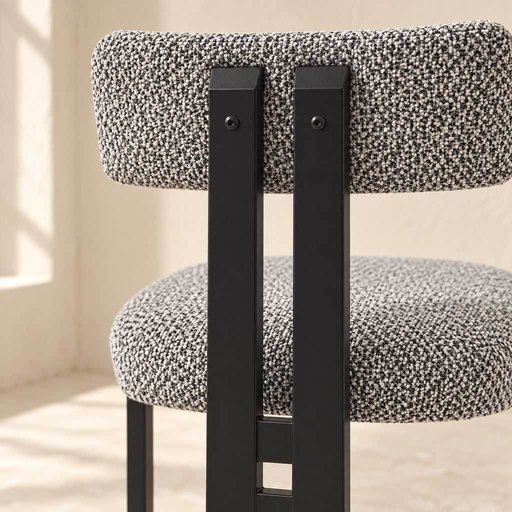 Nola dining chair rear supports in black metal beneath a curved upholstered back