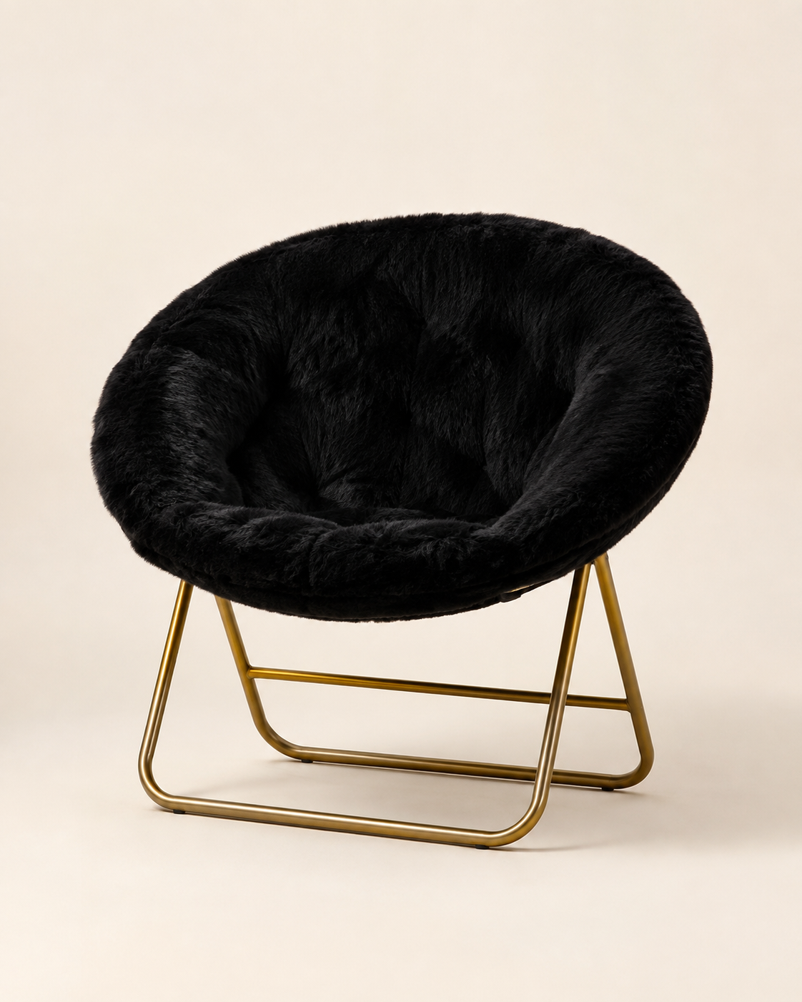 A modern accent chair featuring a black faux fur cushioned seat on a sleek gold metal frame, set against a solid warm beige background.